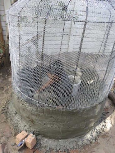 Imraan begins the interior plastering after placing the tank outlet valve bottom left