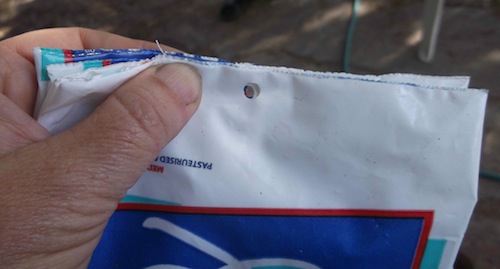 holes punched in the bottom of some milk packets