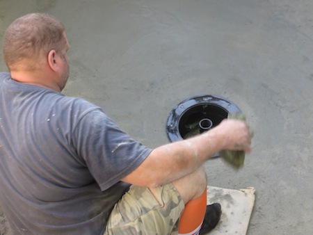 Marc sponges away the concrete splatter from the pond building